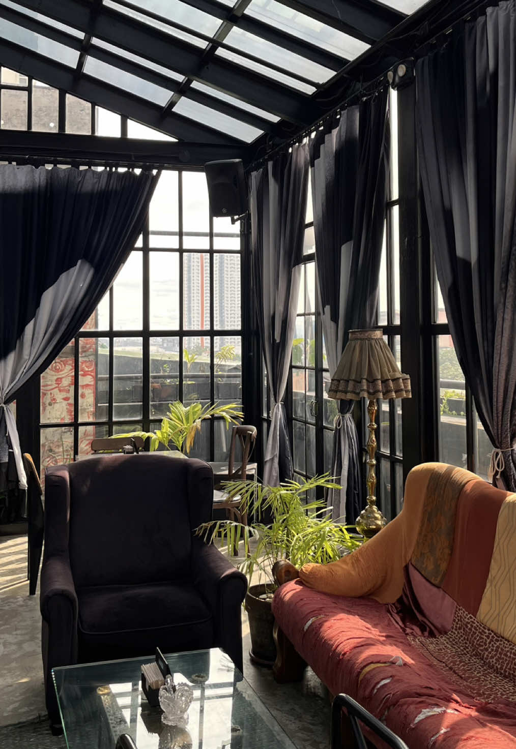 Seltsam shabby-chic interior with vintage armchairs, curtains and glass walls